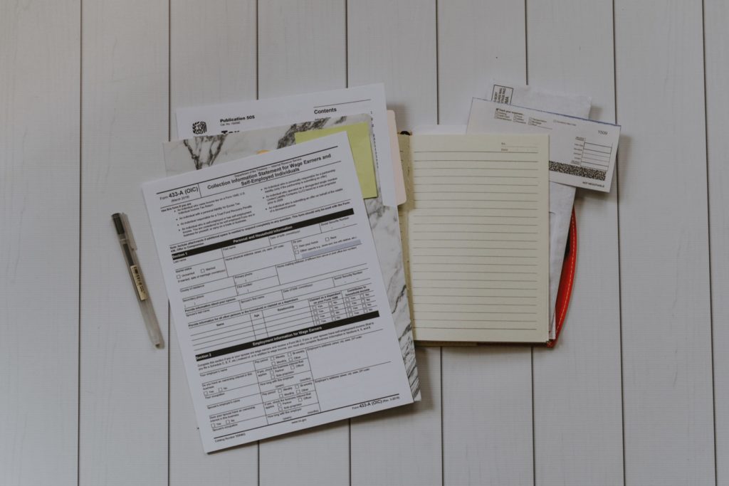 A photograph of many tax forms, notebooks, checks, and papers in a pile.